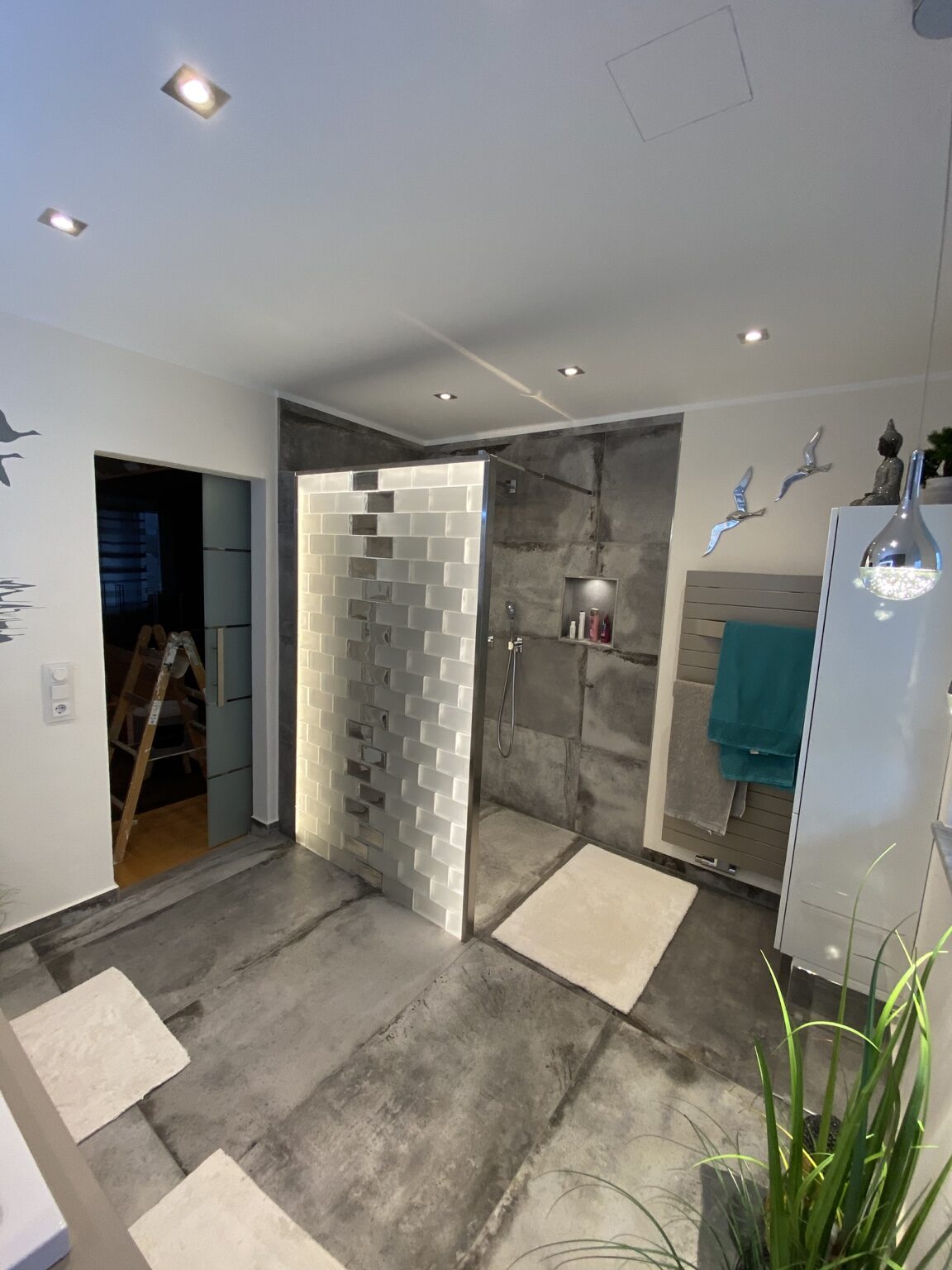 Modernes Badezimmer mit beleuchteter Trennwand und bodengleicher Dusche